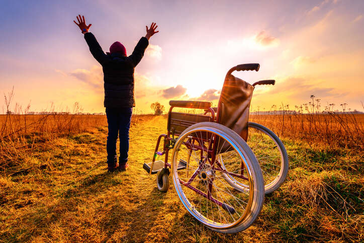 handicap leaves her wheel chair and stand .