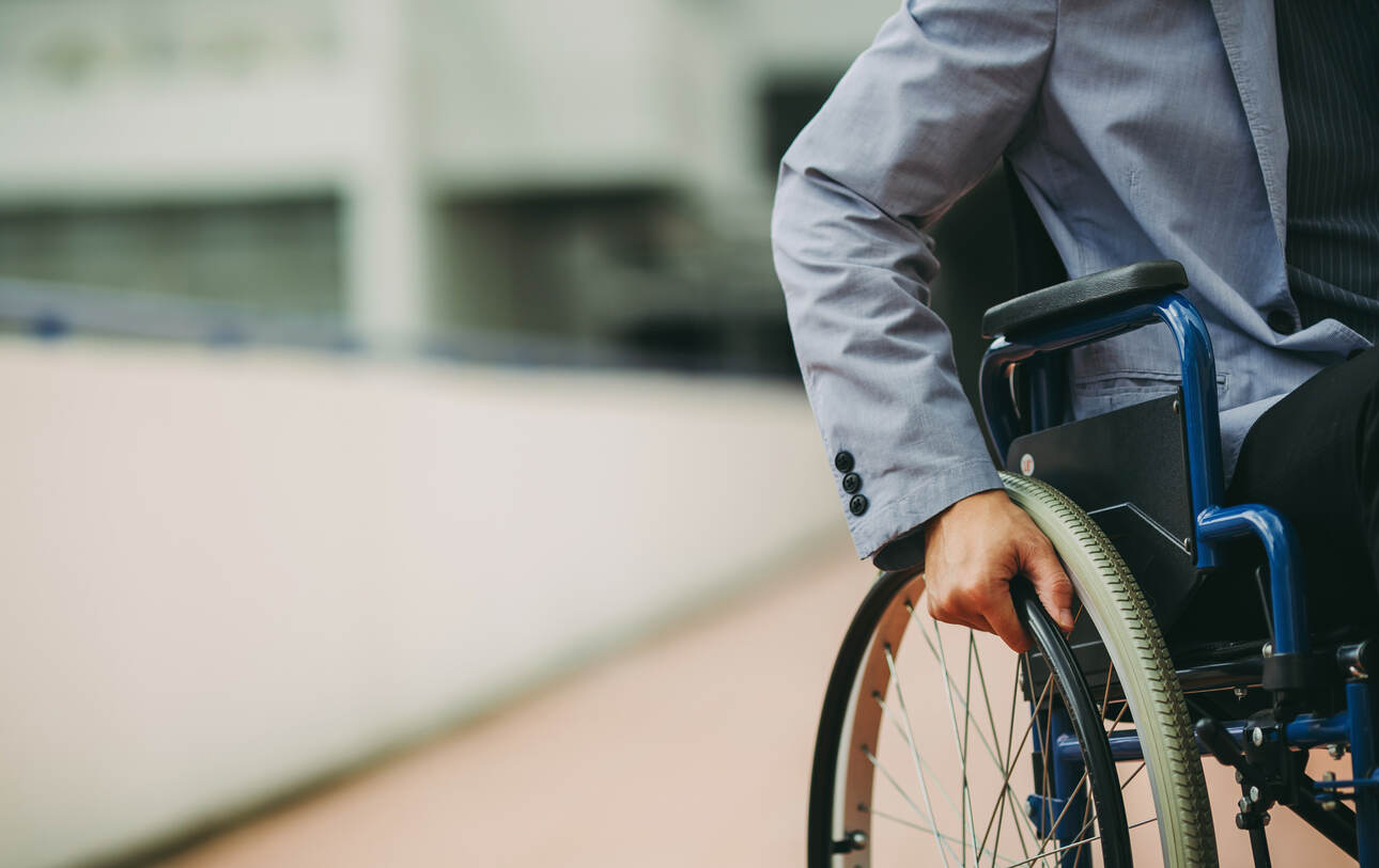 A person in a wheelchair, symbolizing the challenges of insurer delays in disability claims.